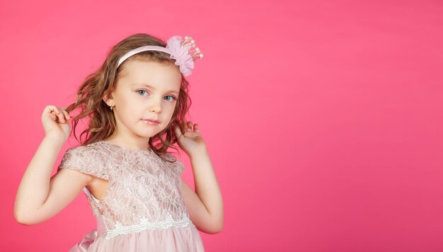 Retrato de menina de 5 a 6 anos em um vestido rosa isolado