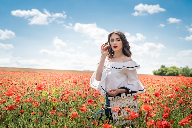 Retrato de menina de beleza e moda em campo de papoulas. horário de verão