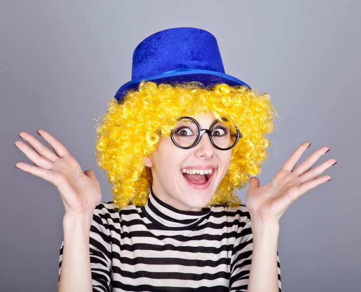 Foto retrato de menina de cabelos amarelos com boné azul e jaqueta de malha listrada.