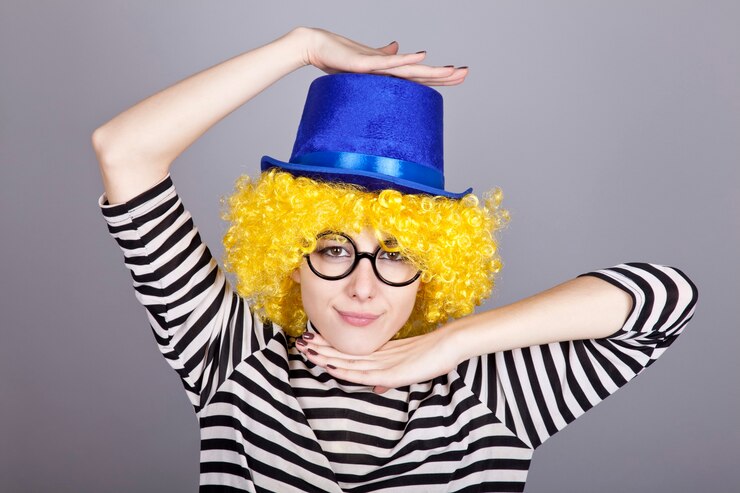 Foto retrato de menina de cabelos amarelos com boné azul e jaqueta de malha listrada.