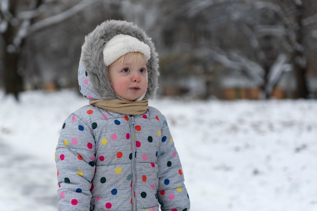 Retrato de menina de macacão no contexto da paisagem de inverno.