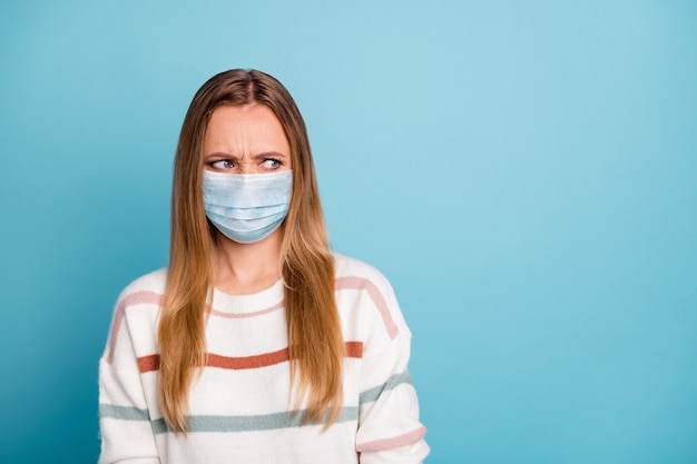 Retrato de menina doente irritada com máscara de segurança cov sintoma da gripe isolado fundo azul