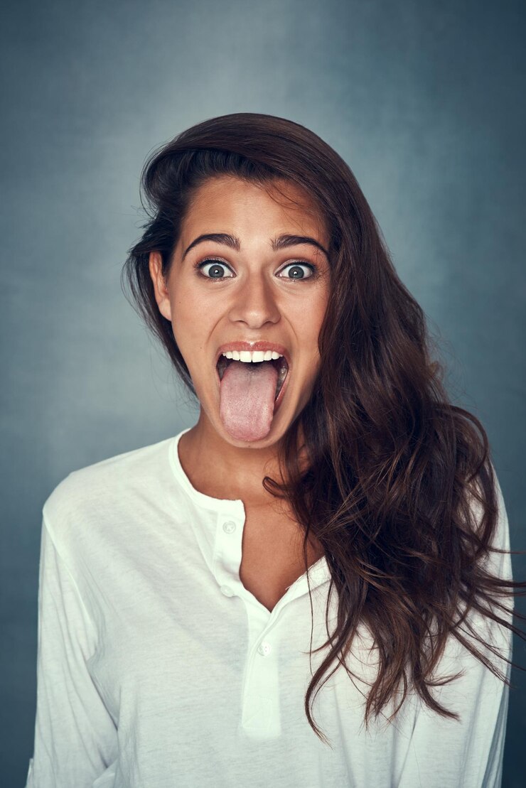 Foto retrato de menina e língua para a moda em estúdio para o fundo de estilo elegante e roupa em fundo cinza pessoa feminina gen z e expressão excitada em cosmética positiva com orgulho ou confiança