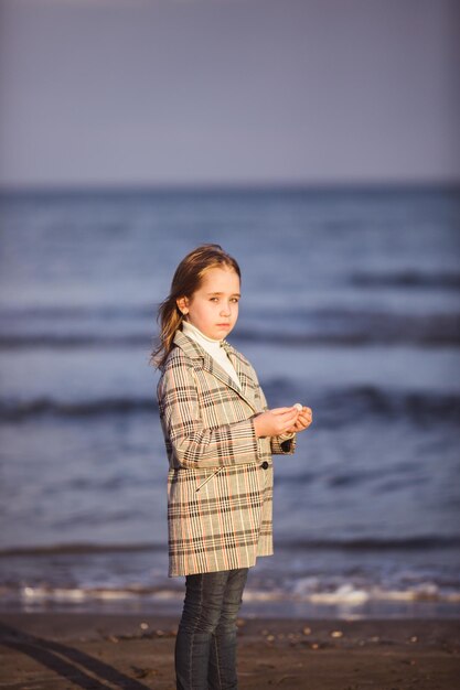 Retrato de menina elegante andando perto do mar