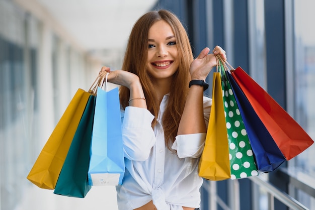 Foto retrato de menina em pé no shopping depois de fazer compras