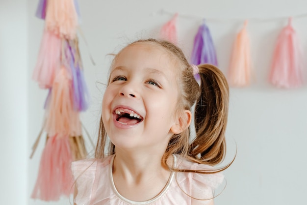 Retrato de menina feliz com decoração de festa. Conceito de celebração guirlanda de papel de borla