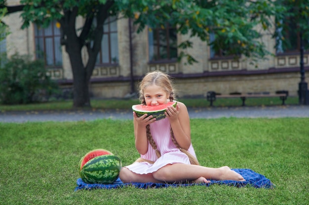 Retrato de menina feliz com melancia desfrutando de verão ao ar livre durante o dia