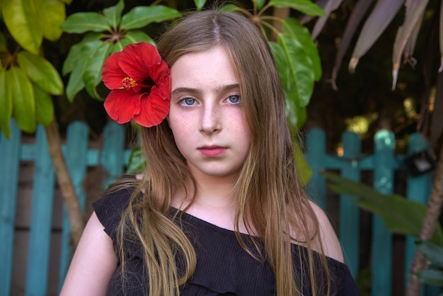 Retrato de menina garoto loiro com flor vermelha