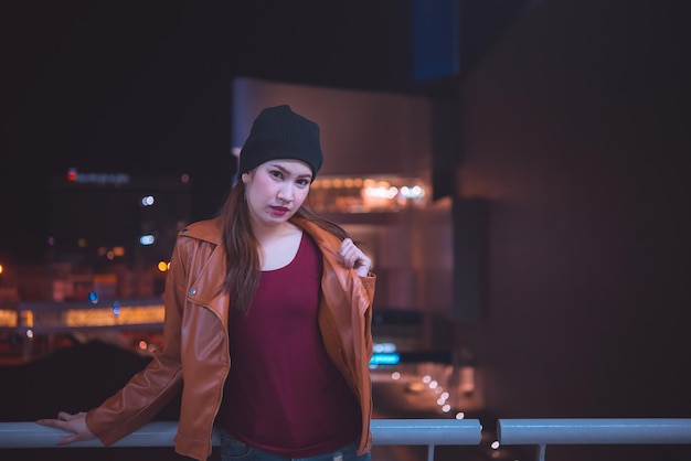 Retrato de menina hipster asiática na cena noturna do parque de estacionamento pessoas da tailândia