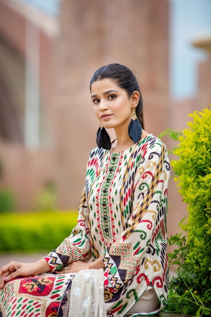 Retrato de menina inocente e fofa com plantas usando vestido e joias tradicionais Desi para ensaio de moda