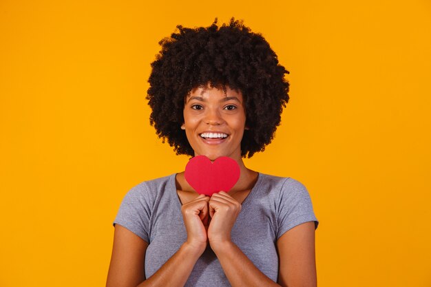 Retrato de menina isolada segurando um coração de papel amarelo