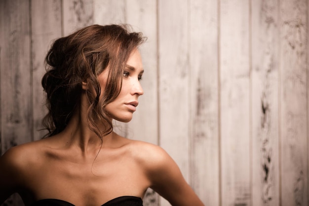 Retrato de menina modelo profissional isolada em fundo de madeira linda senhora posinf para fotógrafo em estúdio fotográfico