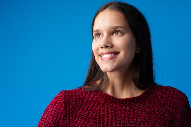 Retrato de menina muito sorridente contra o fundo azul no estúdio