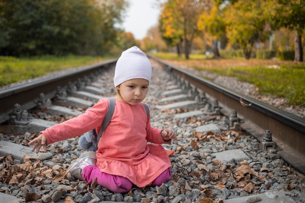 Foto retrato de menina sentada nos trilhos do trem na floresta