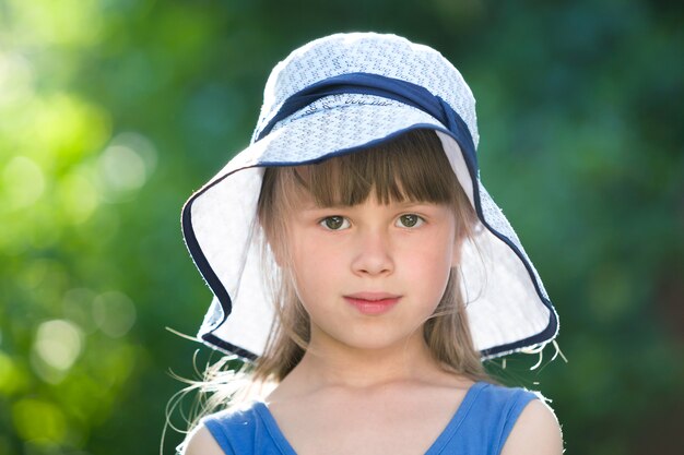 Retrato de menina séria em um grande chapéu.