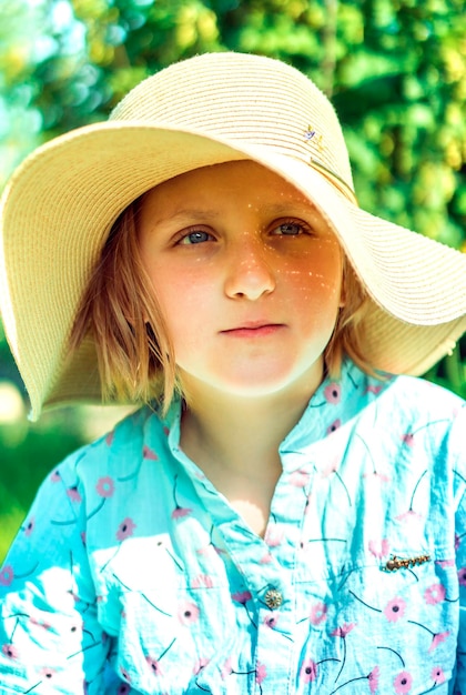 Retrato de menina sorridente com chapéu ao ar livre