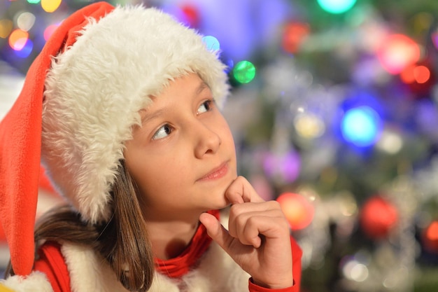 Retrato de menina sorridente no chapéu de Papai Noel