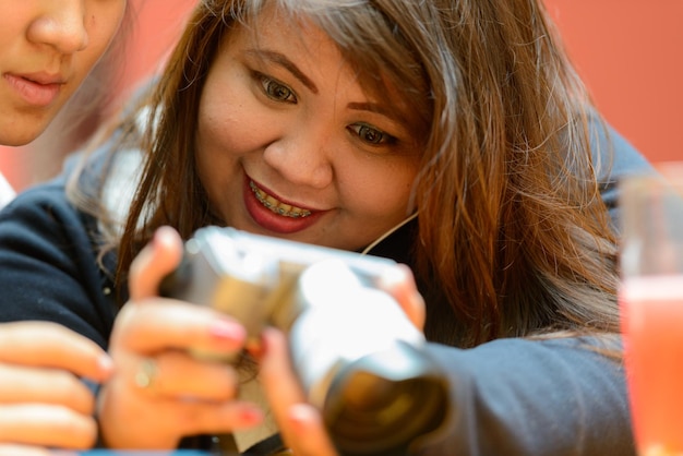 Foto retrato de menina sorridente segurando um smartphone