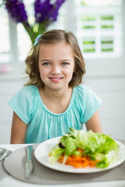 Retrato de menina sorridente, sentado na mesa de jantar