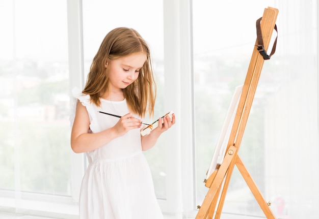 Retrato de menina surpresa pintando uma foto