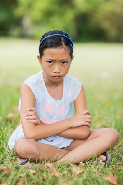 Foto retrato de menina triste sentado na grama