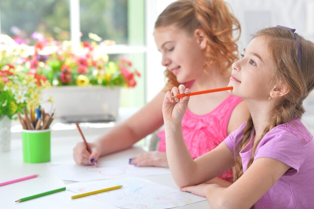 Retrato de meninas desenhando juntos na mesa