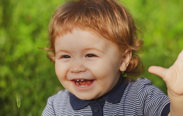 Retrato de menino animado bonito se divertindo no jardim Rosto de bebê close-up Retrato de criança pequena engraçado Rosto de emoção de criança loira Infância feliz e saúde do bebê