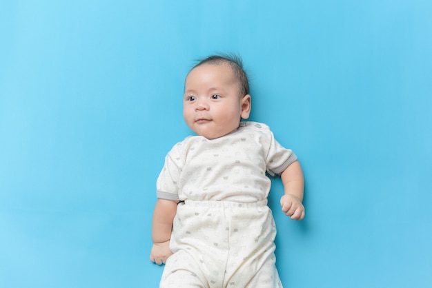 Retrato de menino asiático deitado em azul claro com um espaço de cópia