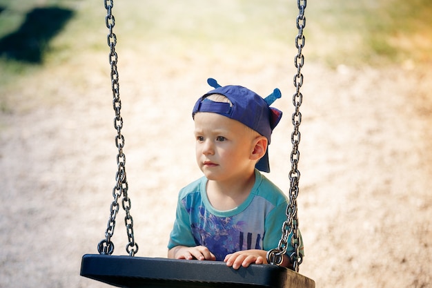 Retrato de menino brincando com balanço no parque