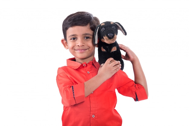 Foto retrato de menino brincando com seu animal de estimação bicho de pelúcia na parede branca