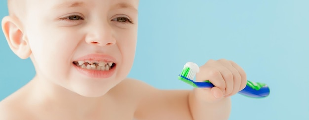 Retrato de menino com escova de dentes em fundo azul