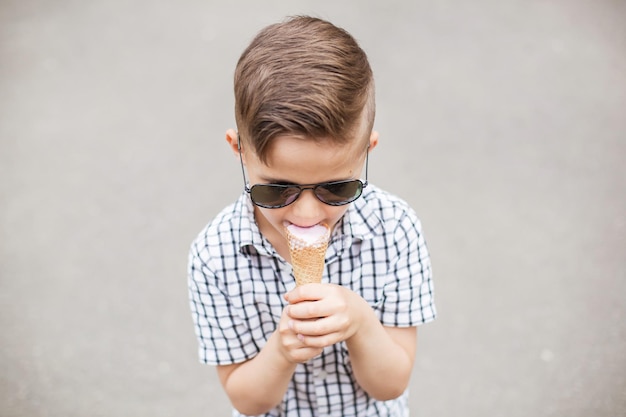 Retrato de menino comendo sorvete ao ar livre