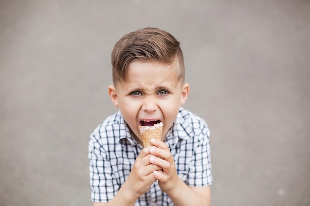 Retrato de menino comendo sorvete ao ar livre