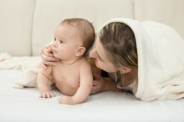 Retrato de menino deitado na cama com a mãe