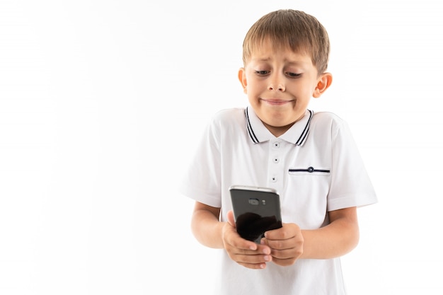 Retrato de menino feliz conversando com seus amigos ou jogando jogos de telefone e triste