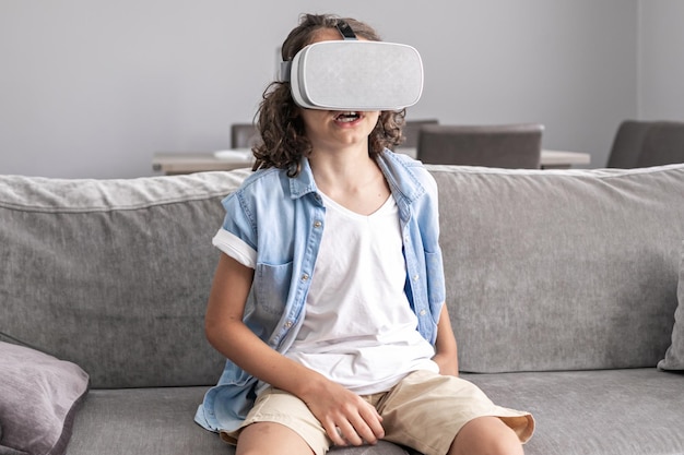 Retrato de menino feliz usando óculos de realidade virtual fone de ouvido vr gesticulando em casa divertida