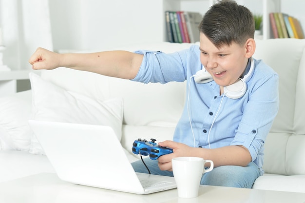 Retrato de menino jogando jogo de computador com laptop