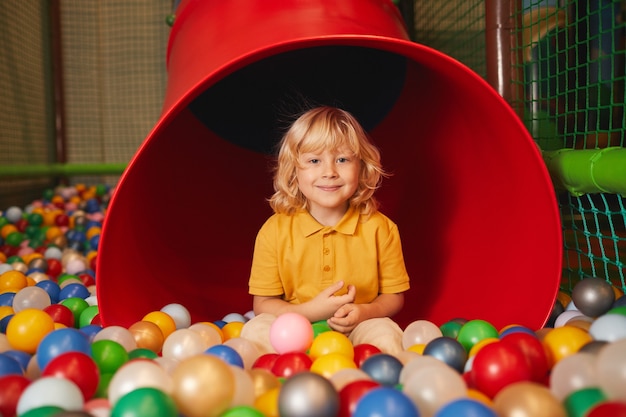 Retrato de menino olhando para frente enquanto brinca no parque de diversões