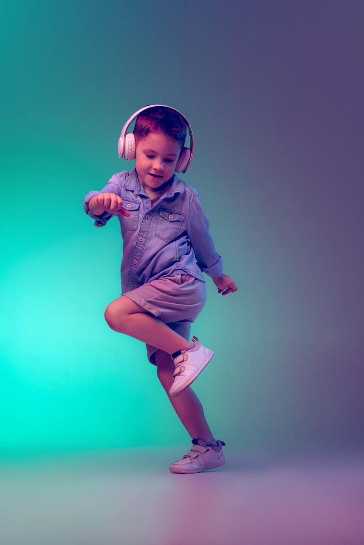 Foto retrato de menino posando em fones de ouvido isolados sobre fundo roxo gradiente verde na luz neon