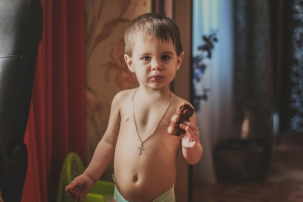 Retrato de menino segurando comida enquanto está em casa