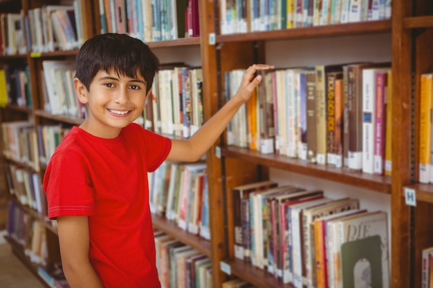 Retrato de menino selecionando livro na biblioteca