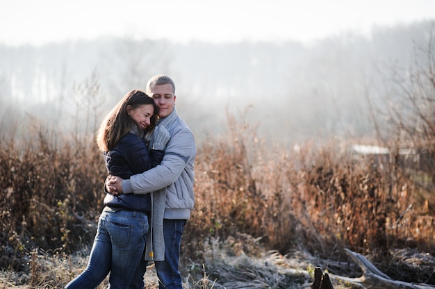 Retrato de moda ao ar livre do jovem casal sensual em água fria de inverno. amor e beijo