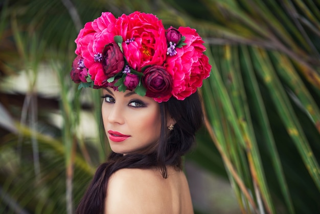 Retrato de moda beleza de uma linda menina morena com coroa de flores na cabeça