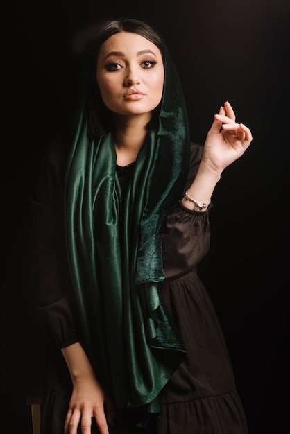 Retrato de moda de mulher de lenço verde ou hidjab posando em fundo escuro