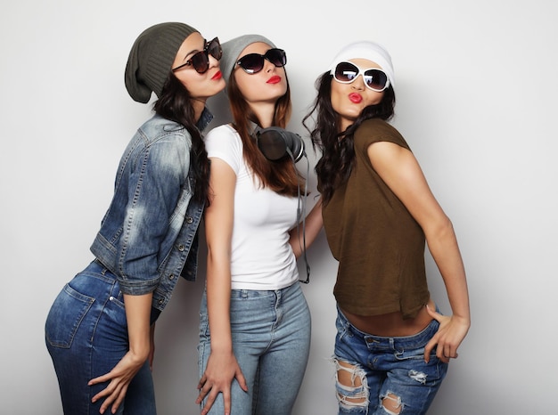 Retrato de moda de três raparigas hipsters elegantes e sexy, melhores amigas.