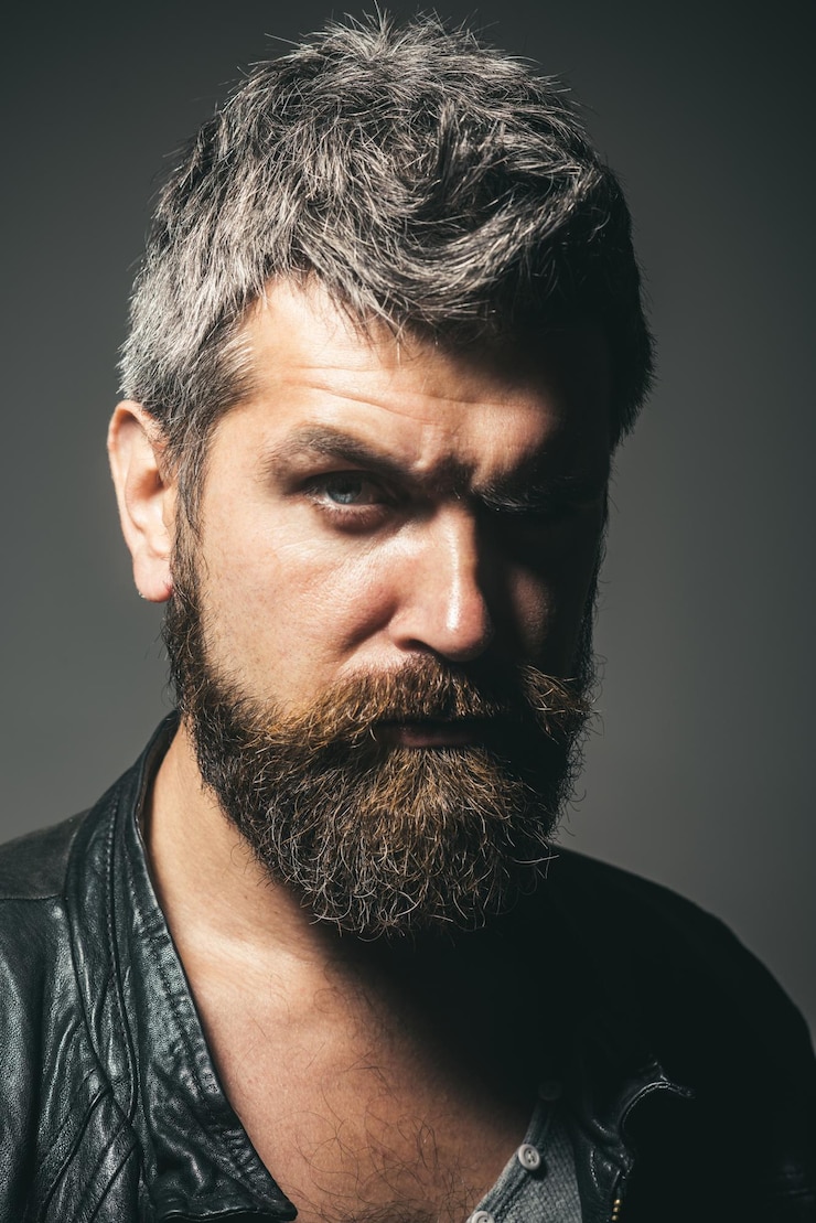 Foto retrato de moda sazonal de moda masculina de homem com barba barba sedutor sexy em couro preto