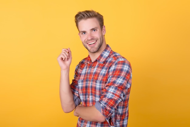 Retrato de modelo de homem bonito. homem carismático, vestindo camisa quadriculada. cara de camisa xadrez em pé com os braços cruzados. seu penteado perfeito. aliciamento masculino na barbearia. olhar na moda da moda.