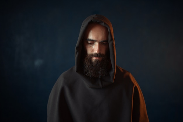 Retrato de monge medieval em túnica preta com capuz