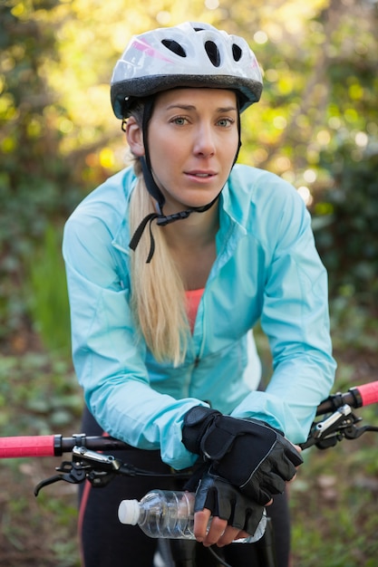 Retrato de motociclista feminino de montanha com bicicleta