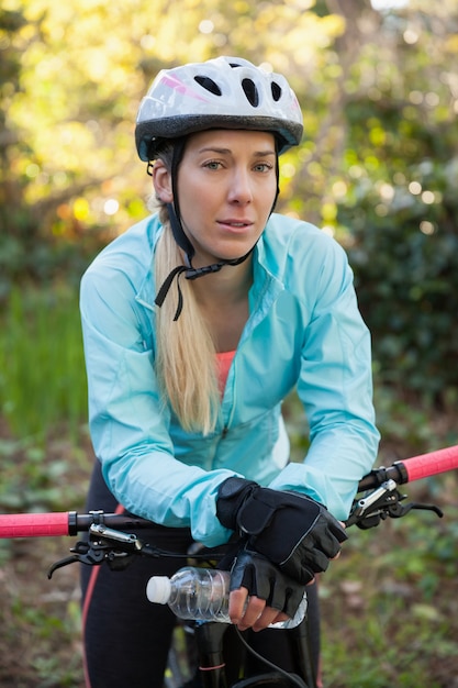 Retrato de motociclista feminino de montanha com bicicleta